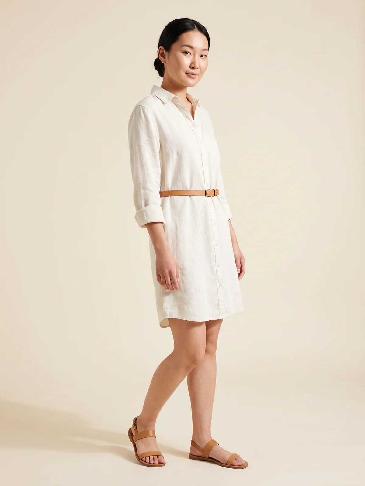 Woman in a belted ivory linen shirt dress