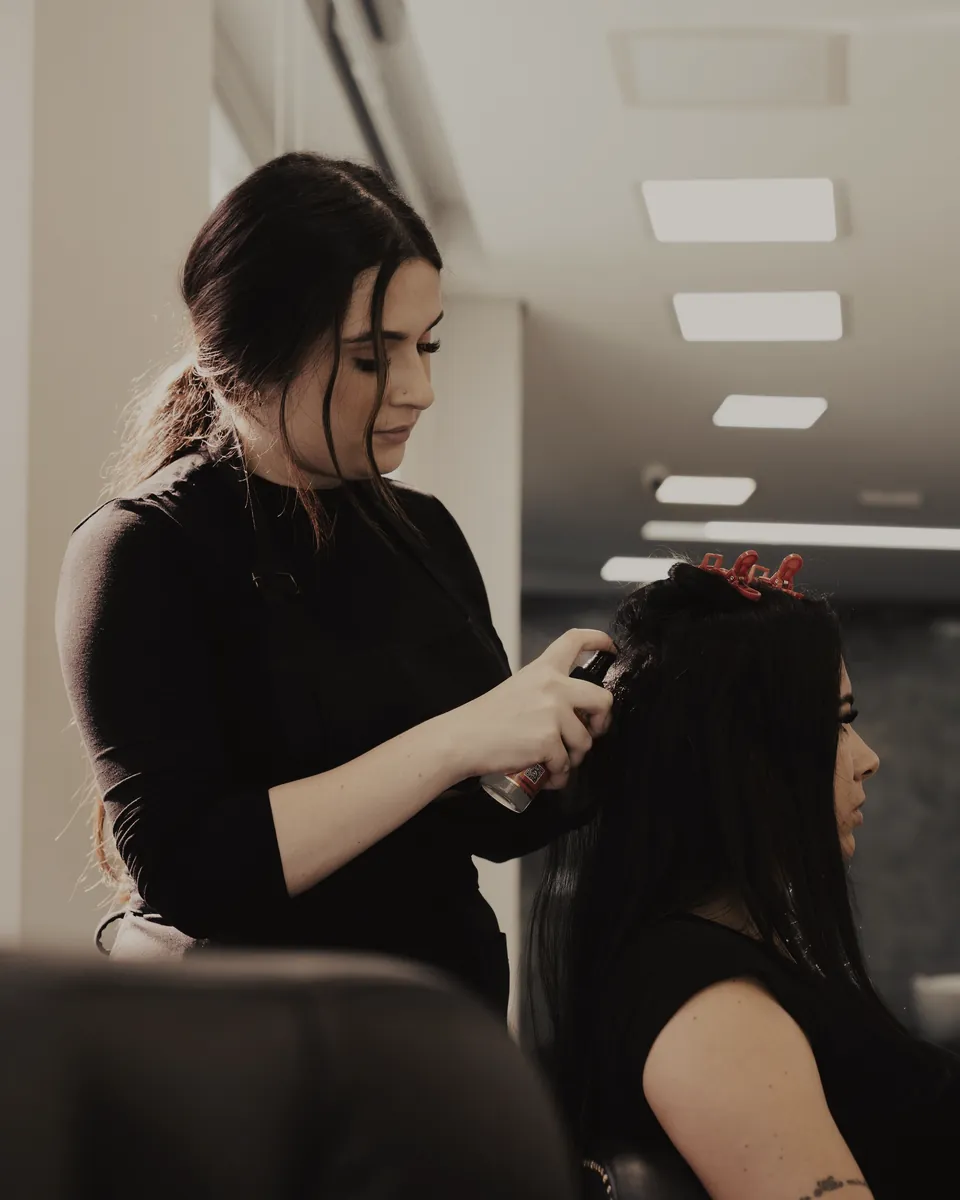 A stylist styling a client’s hair
